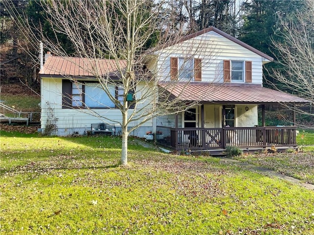 view of front of home with covered porch, metal roof, and a front lawn