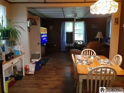 dining space featuring a drop ceiling and dark wood-type flooring