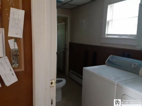 clothes washing area featuring washing machine and dryer and baseboard heating