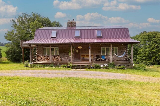 log-style house featuring a porch and a front yard