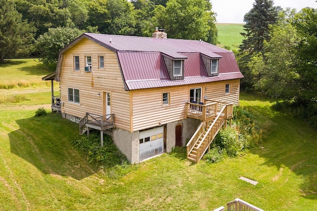 back of property featuring a garage, a yard, and a wooden deck