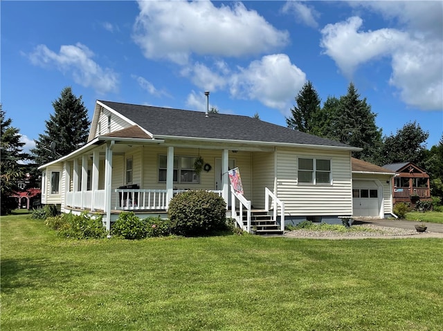 view of front facade with a front yard, covered porch, and a garage