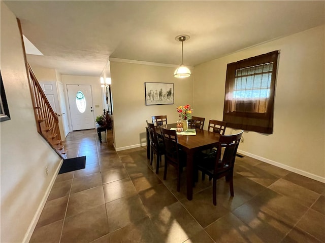 dining room featuring crown molding and dark tile patterned flooring