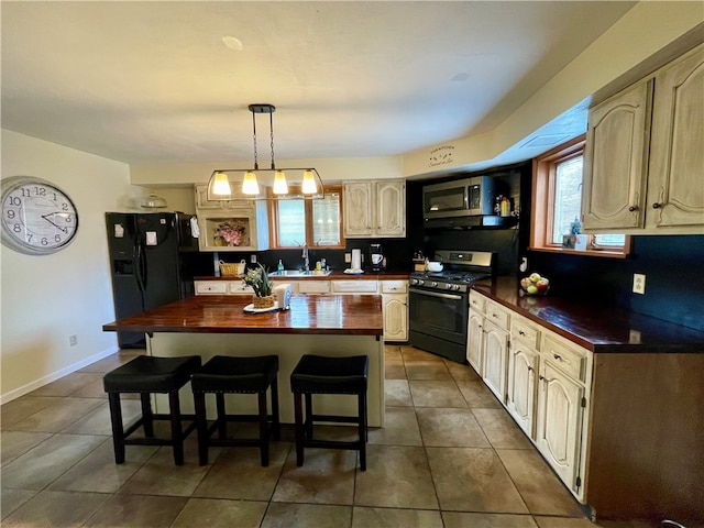 kitchen with stainless steel appliances, sink, a center island, a notable chandelier, and pendant lighting