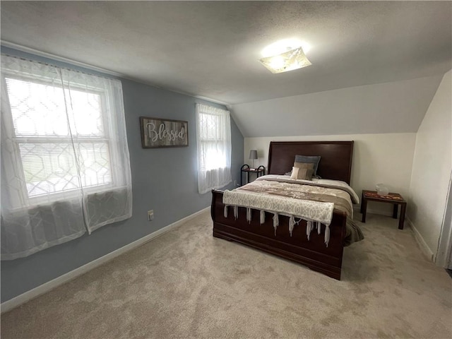 carpeted bedroom with a textured ceiling and vaulted ceiling