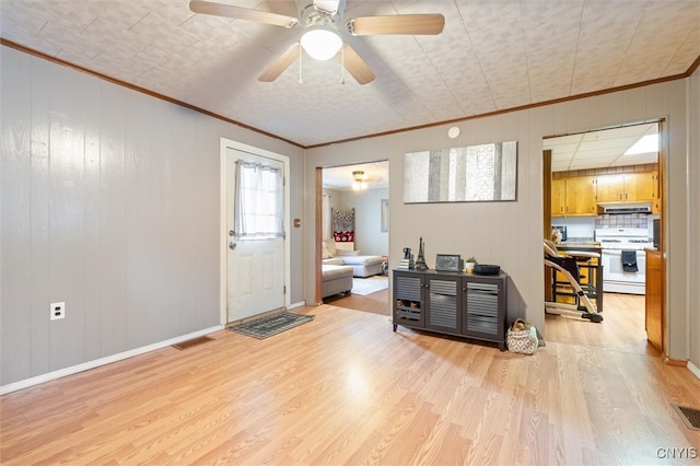 entryway with ceiling fan, light wood-type flooring, crown molding, and a healthy amount of sunlight