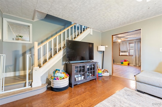 living room featuring ceiling fan, hardwood / wood-style floors, cooling unit, and crown molding