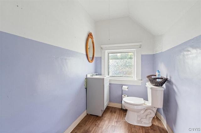 bathroom with vanity, lofted ceiling, hardwood / wood-style floors, and toilet