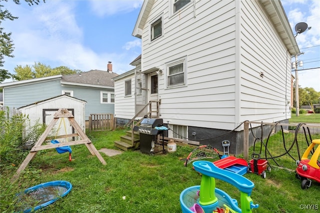 back of property featuring a shed and a yard