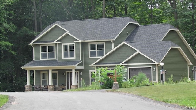 craftsman inspired home featuring a front lawn, a garage, and a porch