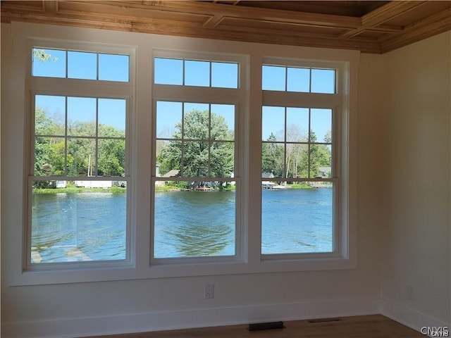 doorway to outside featuring coffered ceiling, plenty of natural light, and a water view