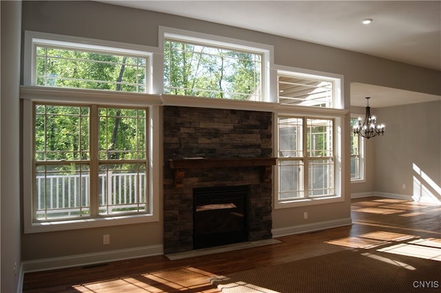 unfurnished living room with hardwood / wood-style flooring, a chandelier, and a fireplace