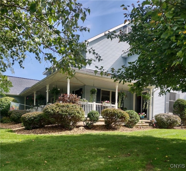 view of side of home featuring a lawn and a porch