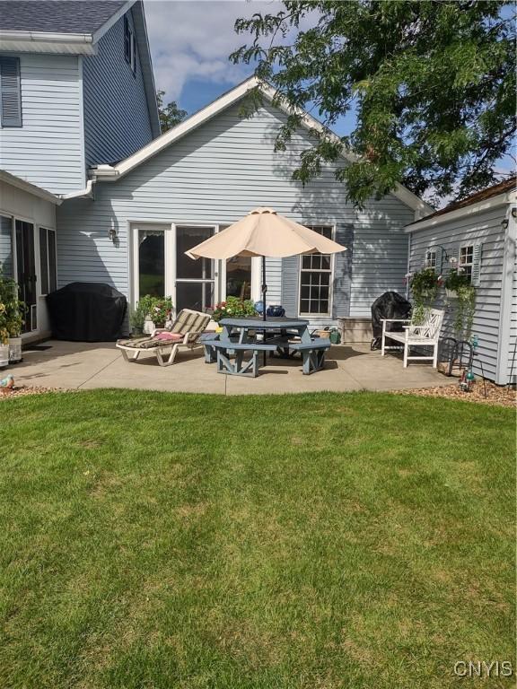 back of house featuring a lawn and a patio area