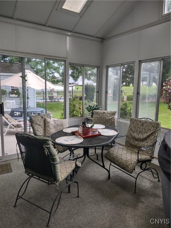 sunroom / solarium featuring vaulted ceiling