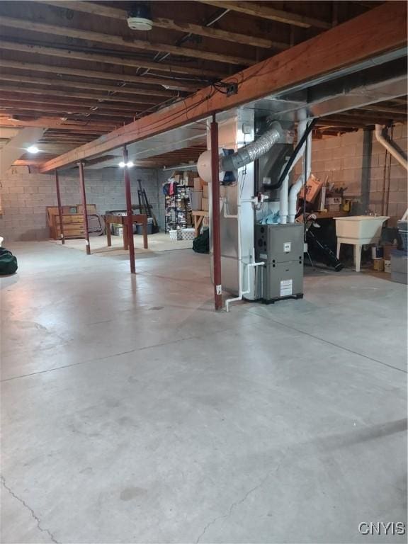 basement featuring heating unit and sink