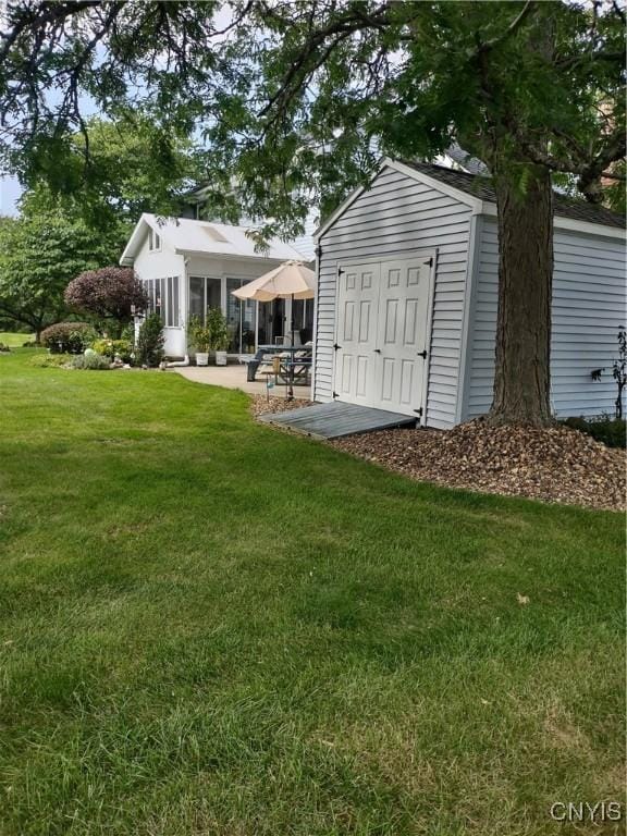 view of outbuilding with a lawn and a sunroom