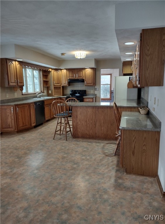 kitchen with sink, a healthy amount of sunlight, a breakfast bar area, and black appliances