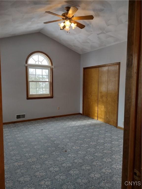 unfurnished bedroom with lofted ceiling, ceiling fan, and carpet