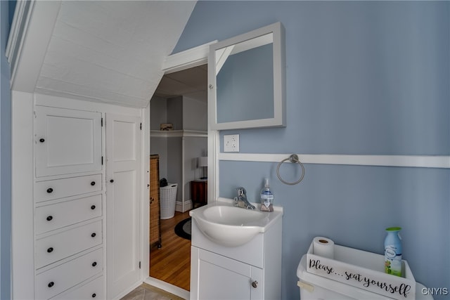 bathroom featuring vaulted ceiling, hardwood / wood-style floors, and vanity