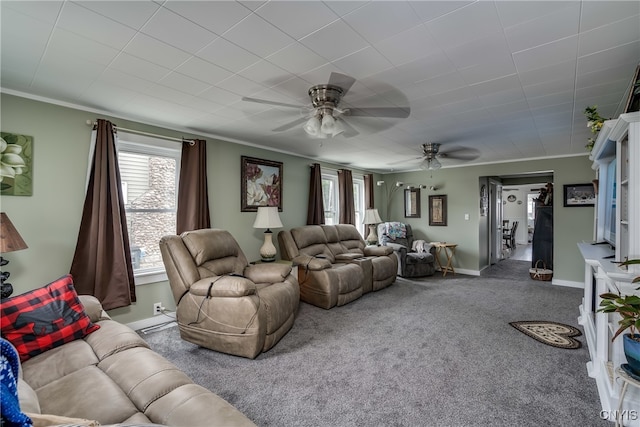 carpeted living room featuring ceiling fan, crown molding, and plenty of natural light