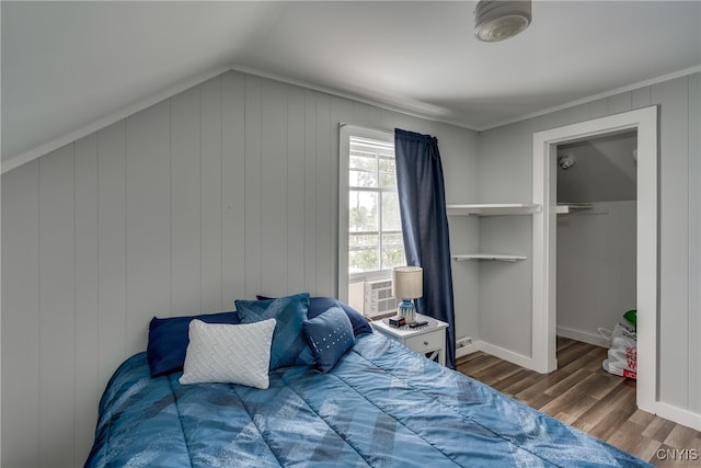 bedroom featuring hardwood / wood-style floors, a spacious closet, and lofted ceiling