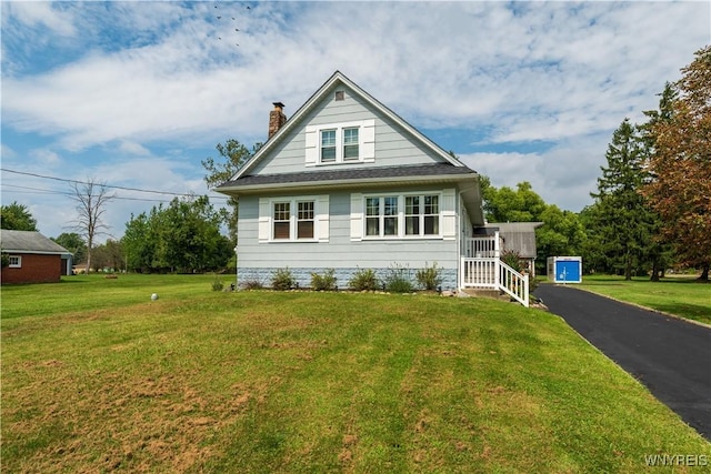 view of front of home with a chimney and a front yard