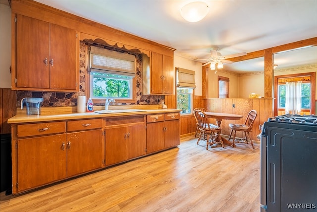 kitchen with a wealth of natural light, black stove, sink, and light wood-type flooring