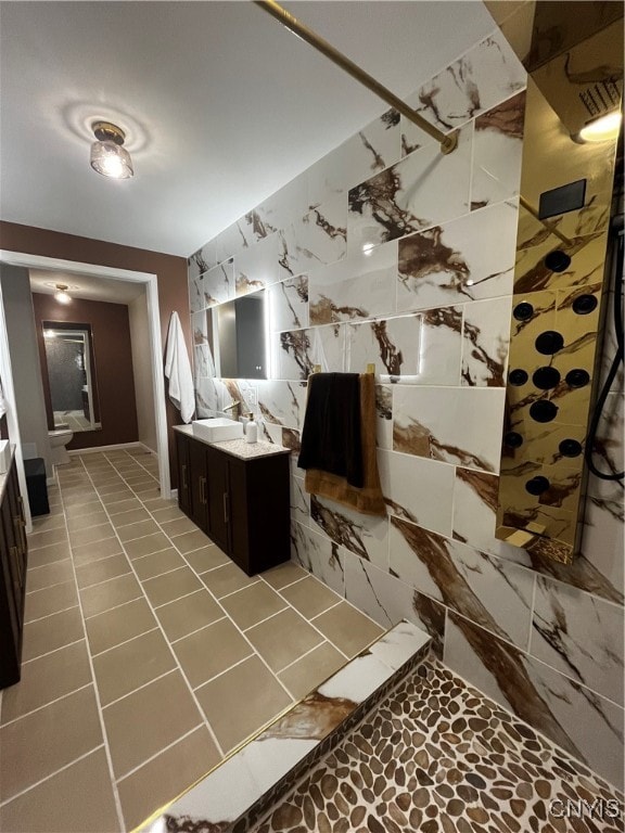 interior space with vanity, toilet, a shower, and tile patterned floors