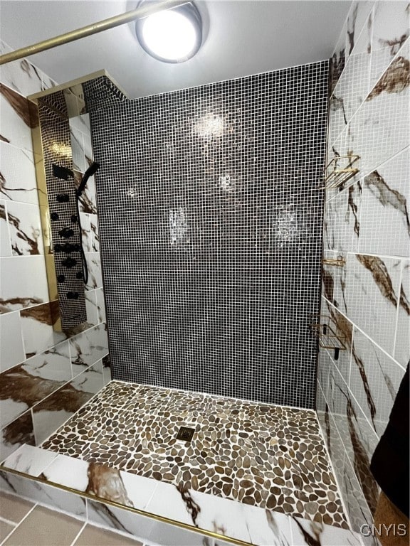 bathroom with tiled shower and tile patterned floors