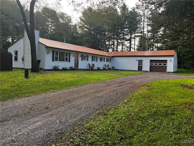 ranch-style home with an outbuilding, a garage, and a front lawn