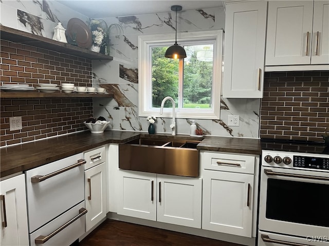 kitchen with wall oven, butcher block countertops, pendant lighting, backsplash, and sink