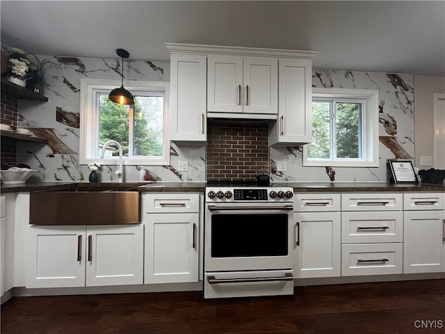 kitchen featuring decorative light fixtures, electric range, white cabinetry, and sink