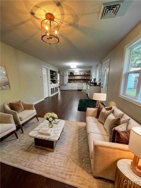 living room with hardwood / wood-style flooring and a notable chandelier