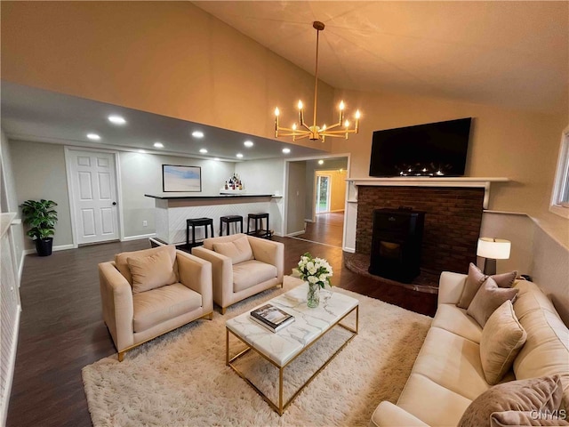 living room featuring high vaulted ceiling, wood-type flooring, a fireplace, and a chandelier