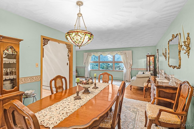 dining area featuring light hardwood / wood-style flooring and a notable chandelier