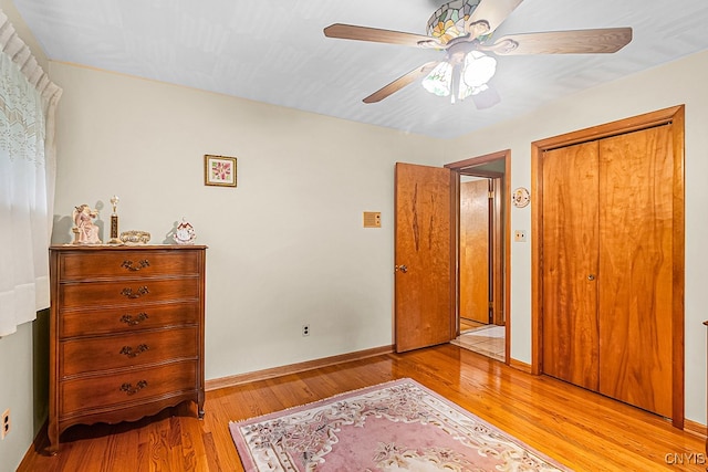 bedroom with ceiling fan, light wood-type flooring, and a closet