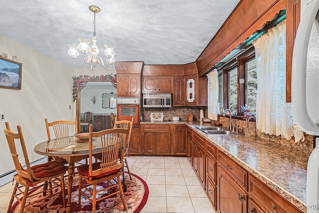 kitchen featuring a chandelier, light tile patterned floors, pendant lighting, and sink