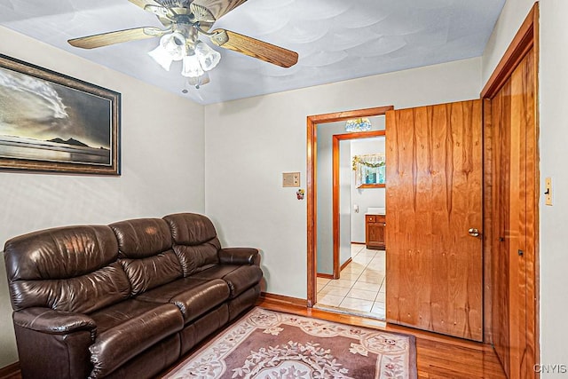 living room with ceiling fan and light hardwood / wood-style flooring