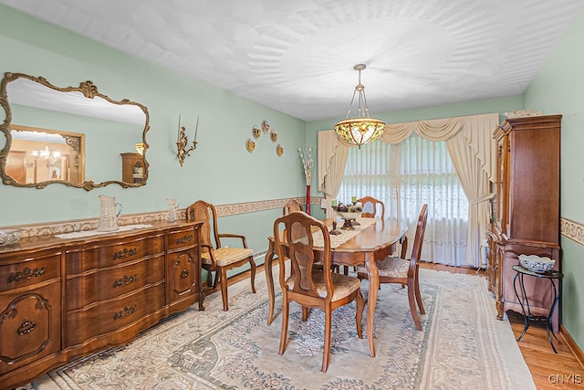 dining room with an inviting chandelier and light hardwood / wood-style flooring