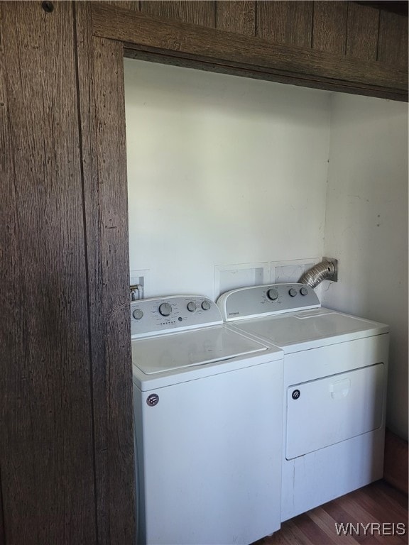 washroom with washing machine and clothes dryer and dark hardwood / wood-style floors