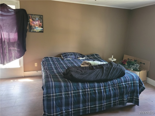 bedroom with ornamental molding and light hardwood / wood-style flooring