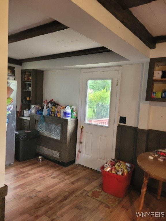 doorway featuring beamed ceiling and hardwood / wood-style floors