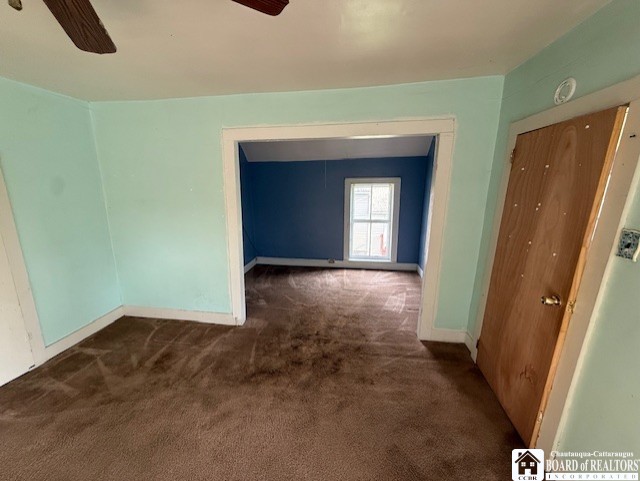 512 N 7th St, Olean-City, NY 14760 - empty room featuring baseboards, ceiling fan, and dark colored carpet