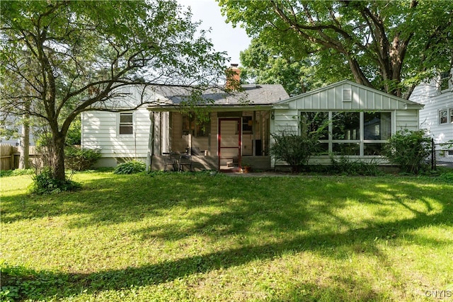 rear view of property featuring a yard