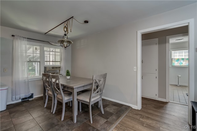 dining area with a wealth of natural light, cooling unit, dark wood-type flooring, and a chandelier