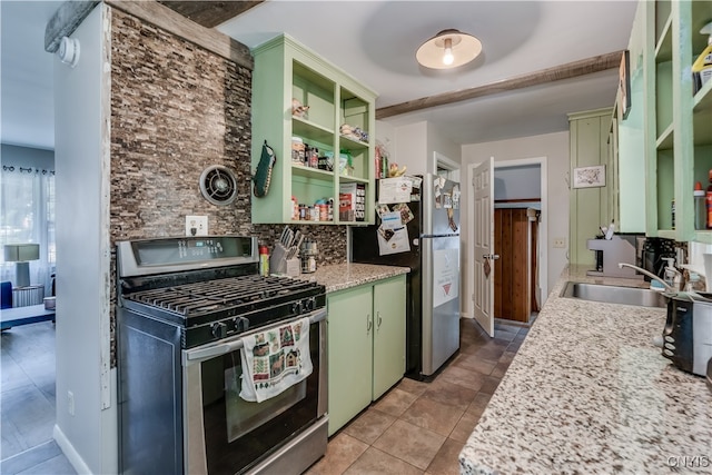 kitchen with sink, decorative backsplash, light tile patterned floors, stainless steel appliances, and green cabinetry