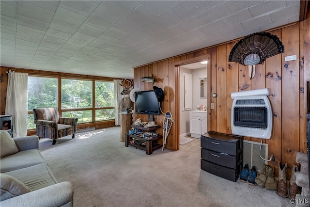 carpeted living room featuring wood walls