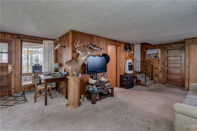 carpeted living room featuring wood walls