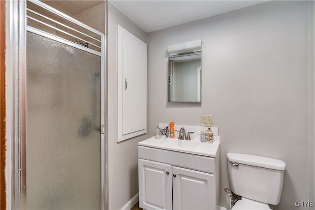 bathroom featuring toilet, an enclosed shower, and vanity